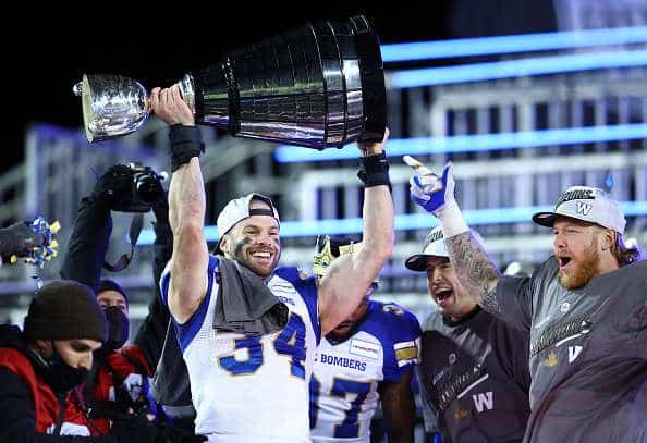 Jesse Briggs of the Winnipeg Blue Bombers holding the Grey Cup.
